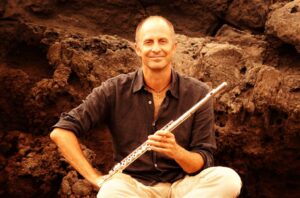 Un hombre sobre una roca con una flauta travesera