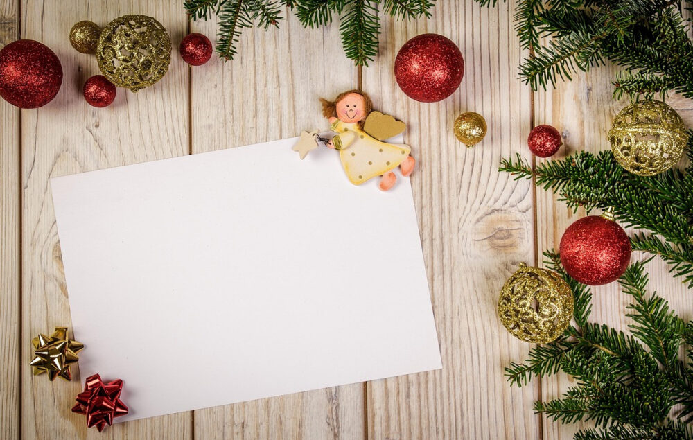 Una carta de navidad sobre un mesa con decoración navideña