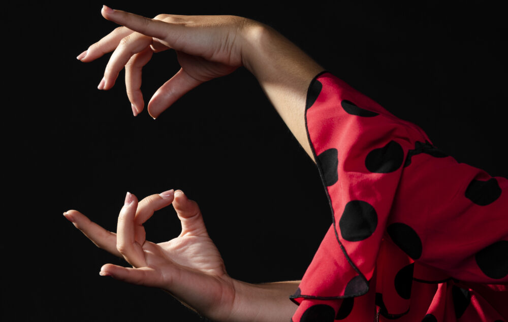 manos de una bailaora flamenca con un traje de luces rojo