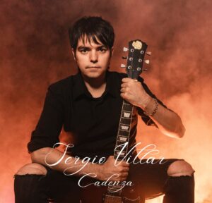 Un hombre sujetando una guitarra con un fondo naranja