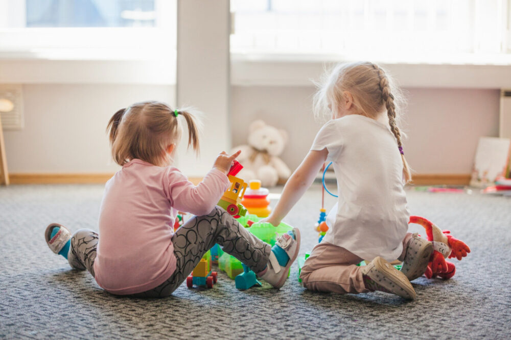 dos niñas pequeñas jugando en un aula