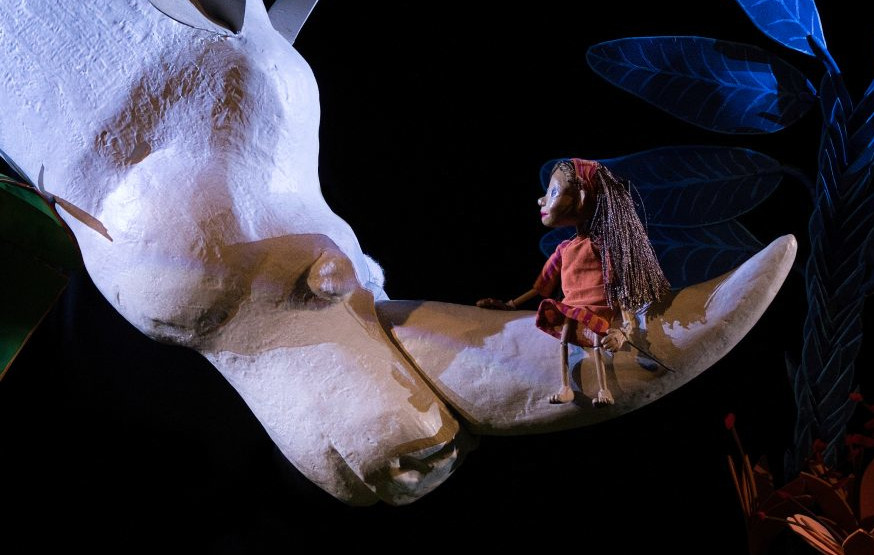 Un niño de marioneta sobre un rinoceronte