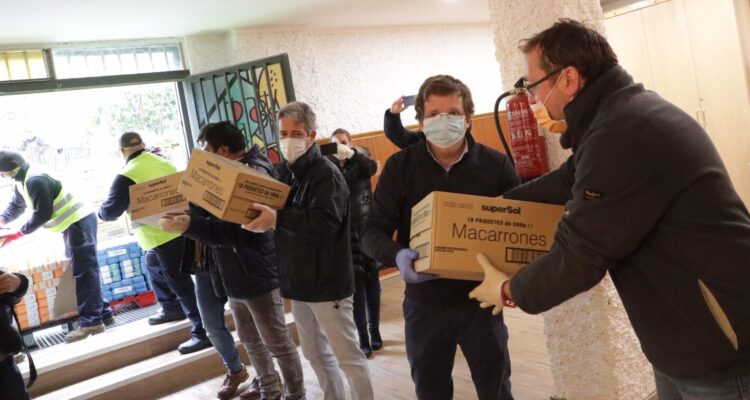 El alcalde descargando cajas en la parroquia de Aluche