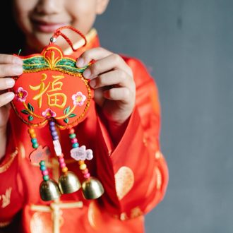 Niño chino con un colgante de abalorios del Año Nuevo Chino