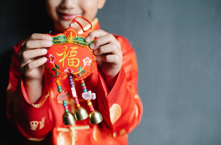 Niño chino con un colgante de abalorios del Año Nuevo Chino