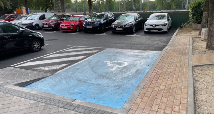 Aparcamiento con una plaza para personas con discapacidad y rampa en primer plano