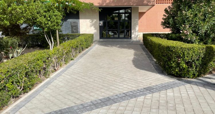 Acceso amplio a un portal con setos a los laterales