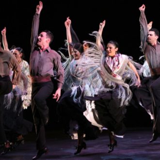 Bailarines de flamenco del espectáculo Naturalmente Flamenco con las manos alzadas