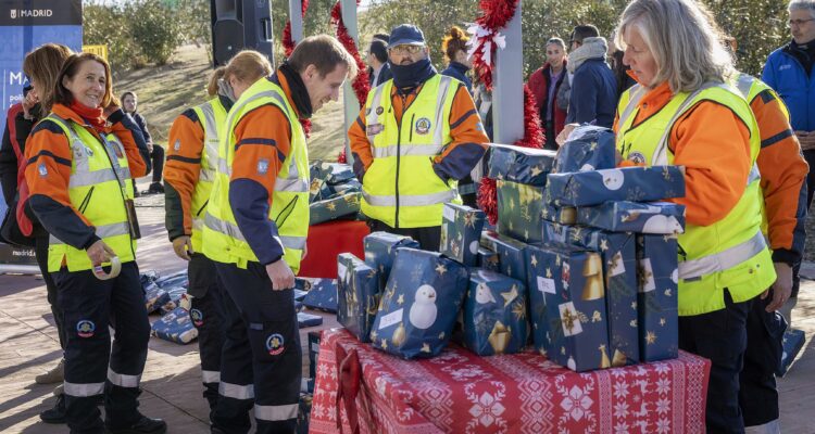 Miembros de SAMUR protección civil durante la entrega de juguetes a los niños alojados en el Centro de Emergencia Temporal Las Caracolas