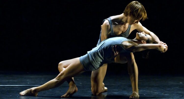 Imagen de dos bailarines en la que un hombre sujeta a una mujer en una postura estirada
