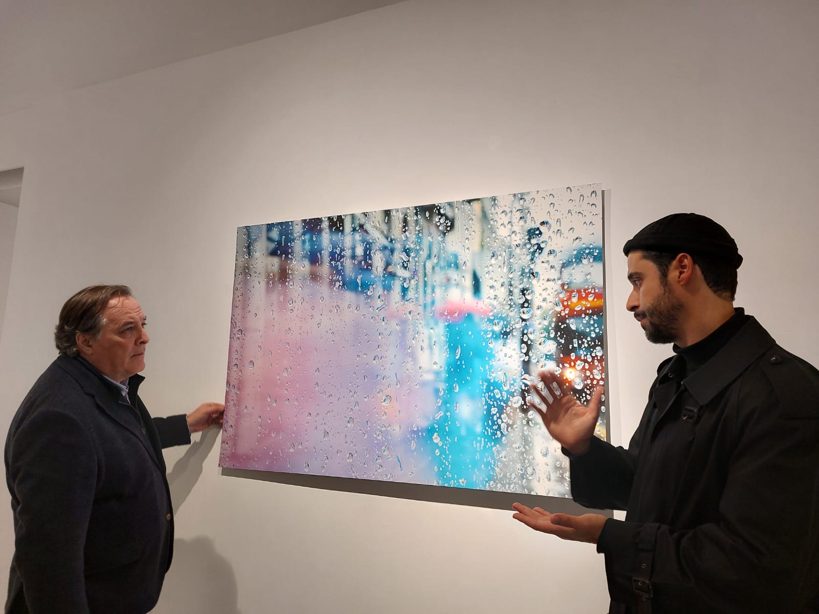 El concejal, Jaime González Taboada, charlando con el artista Christian Baes frente a su obra