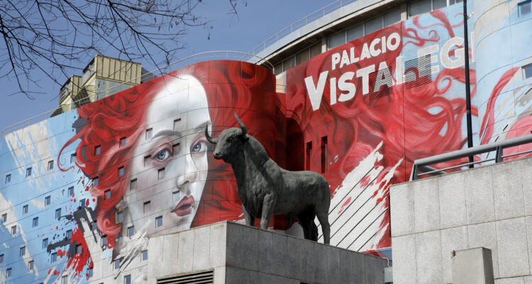Imagen de la fachada del Palacio de Vistalegre que se ve una mujer de pelo rojo