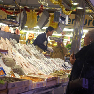 Imagen de archivo de una mujer comprando en una pescadería de Madrid