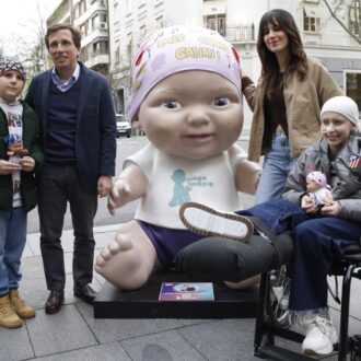 Almeida posa al lado de la figura diseñada por Elena Huelva, ubicada en Velázquez con Jorge Juan, que forma parte de la exposición de baby pelones de Juegaterapia