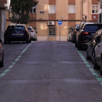 un carretera con coches aparcados a los lados en zona ser