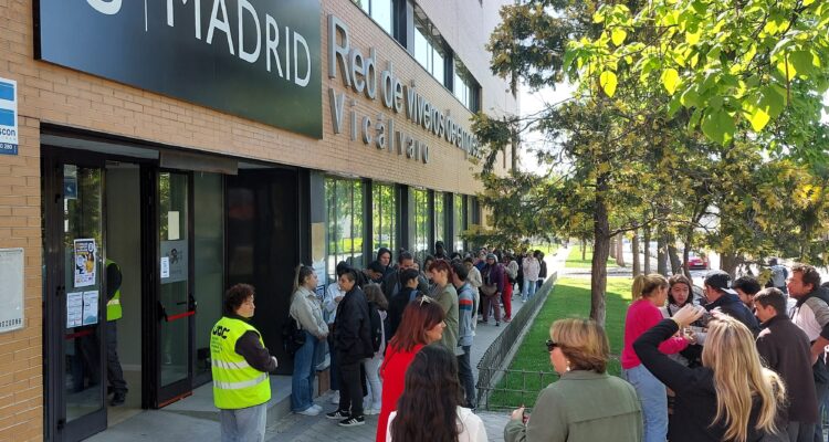 personas hacia cola para entrar en un edificio