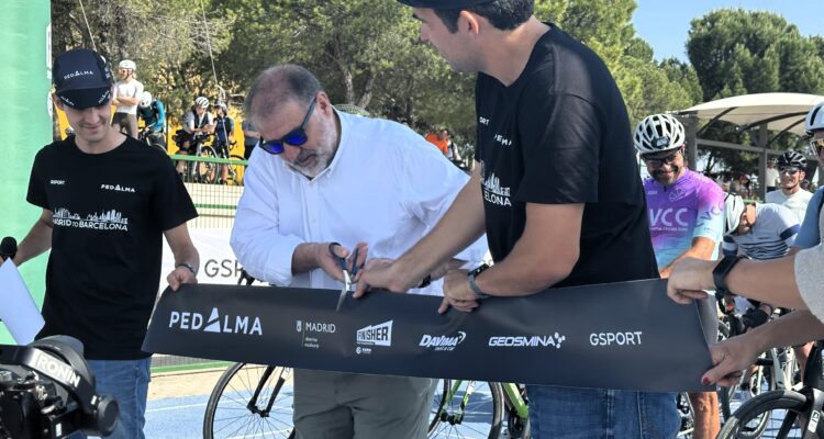 Un hombre cortando con unas tijeras la cinta de salida