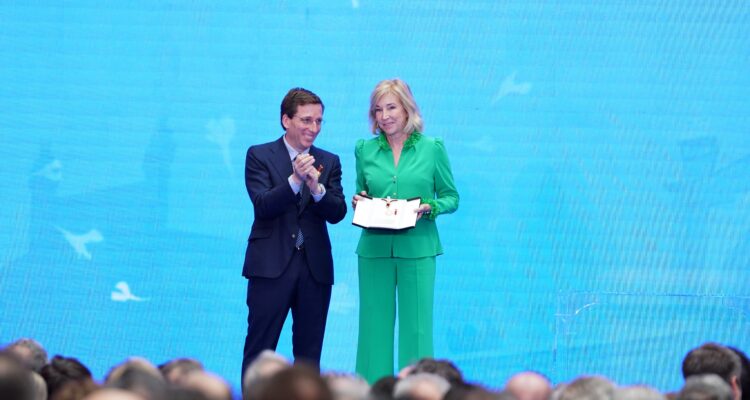 La ejecutiva financiera María Dolores Dancausa recibe su medalla de manos de Almeida