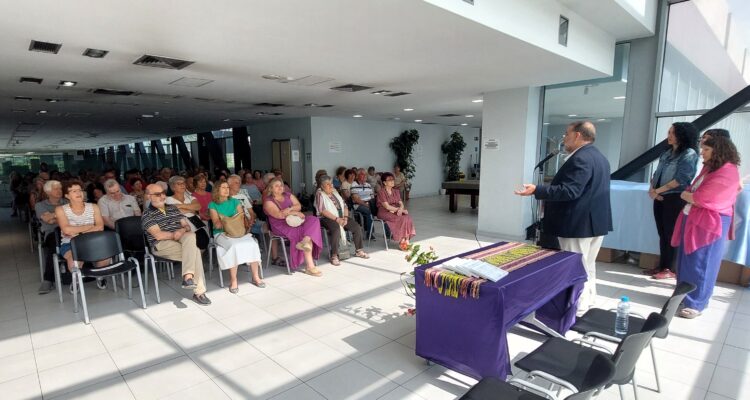 un hombre hablando frente a un grupo de personas mayores que están sentadas