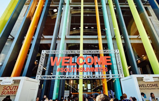 Fachada de La Nave con columnas de colores y el letrero de South Summit en el centro en rojo