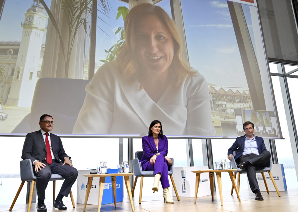 El alcalde de Madrid, José Luis Martínez-Almeida, junto a la alcaldesa de Santander, y la alcaldesa de Valencia en pantalla, durante la presentación del proyecto CAREwell