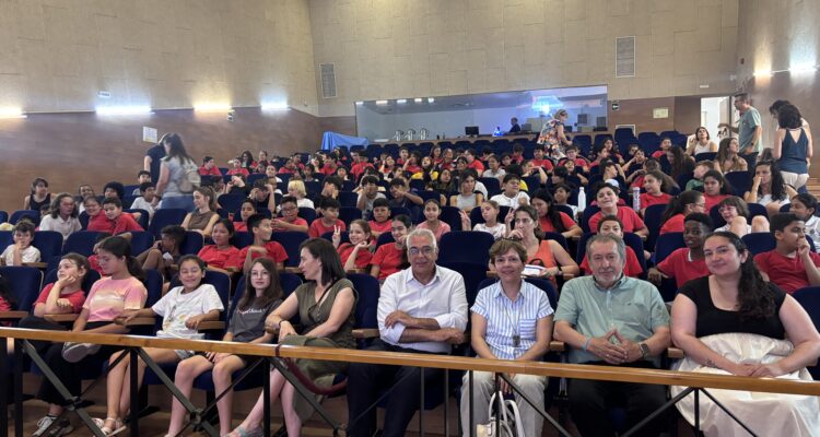 Público en las butacas de un auditorio. Hay adultos en la primera fila y menores al fondo