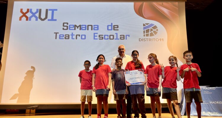 El concejal de Carabanchel con los niños de colegios que han participado en el certamen de teatro sobre una tarima de un escenario
