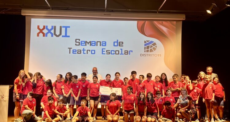 El concejal de Carabanchel con los niños de colegios que han participado en el certamen de teatro sobre una tarima de un escenario