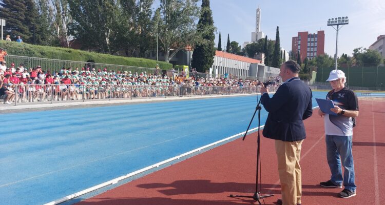 El concejal de distrito, Nacho Pezuela, hablando en una pista de atletismo con los participantes de la 8 jornada de inclusión de Moratalaz en la grada