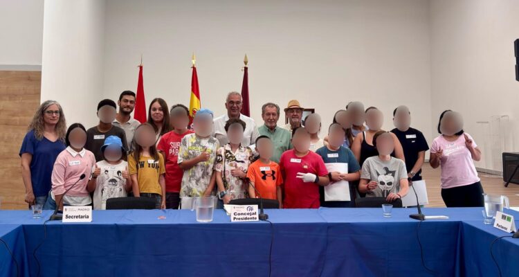 Niños y jóvenes participantes junto al concejal de distrito tras el Pleno