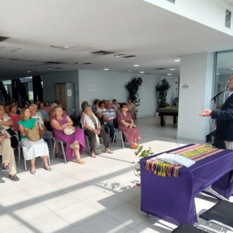 una hombre hablando frente a un grupo de mayores, imagen tomada en la inauguración de la Semana de Mayores de Vicálvaro