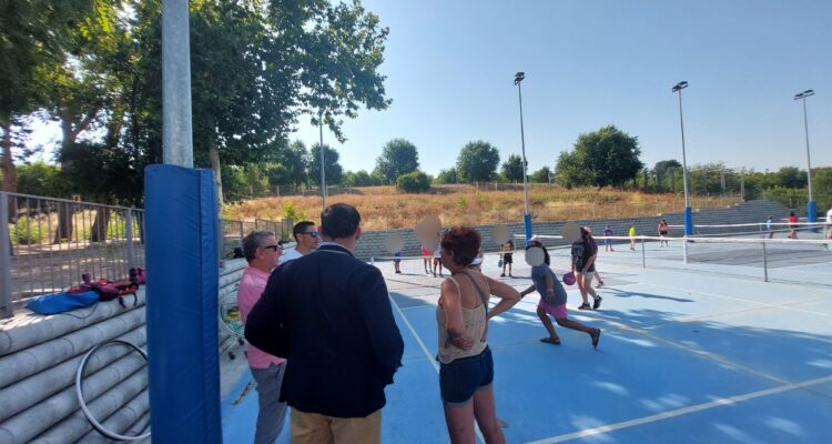 El concejal de Moratalaz, Nacho Pezuela, en una pista de tenis con adolescentes participantes en el campamento