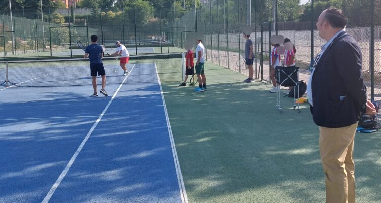 El concejal de Moratalaz, Nacho Pezuela, en una pista de tenis con adolescentes participantes en el campamento