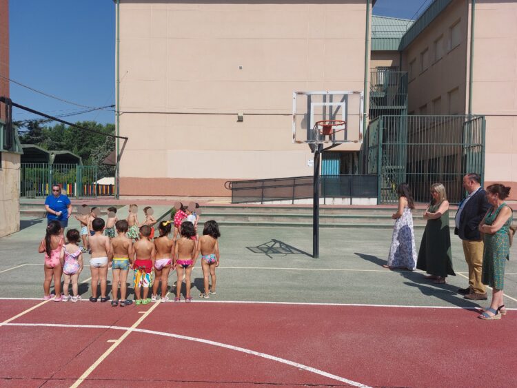 El concejal de Moratalaz, Nacho Pezuela, en el recorrido por los campamentos de verano del distrito con un grupo de niños y niñas de espaldas