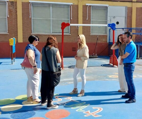 un grupo de personas adultas en el patio de un colegio