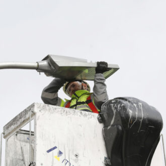 Operario cambiando el alumbrado. Imagen de archivo