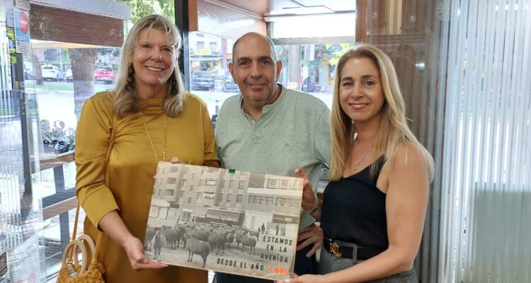 dos mujeres y dos hombres sujetando un cartel de un local 'Treintañero de Ciudad Lineal'