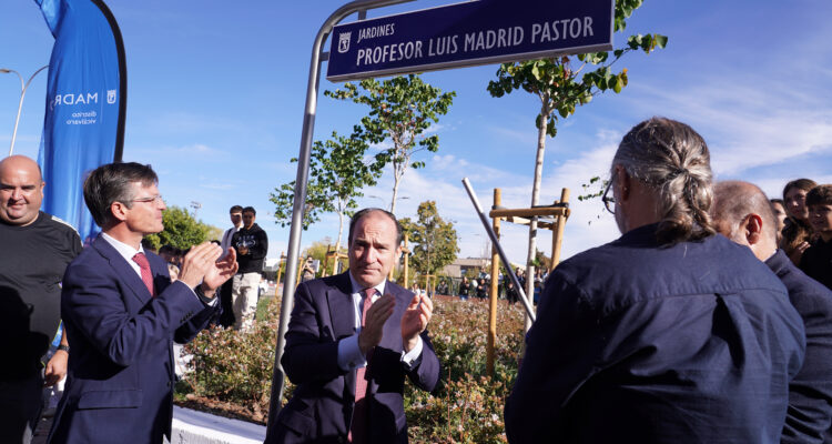 tres hombres aplaudiendo frente la placa que da nombre a los jardines de Luis Madrid Pastor