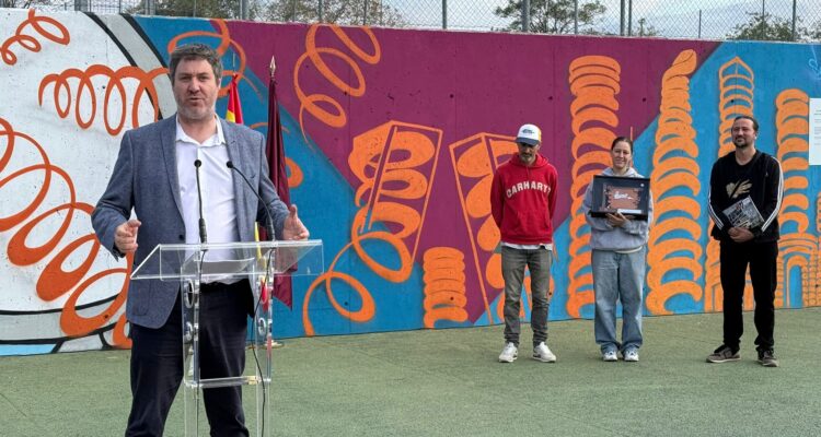 El concejal del distrito, Alberto González, en el acto del entrega de los galardones, con los premiados al fondo