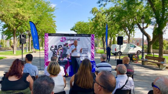 Un hombre hablando ante un público al aire libre