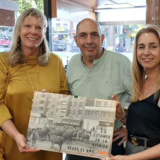 dos mujeres y dos hombres sujetando un cartel de un local 'Treintañero de Ciudad Lineal'