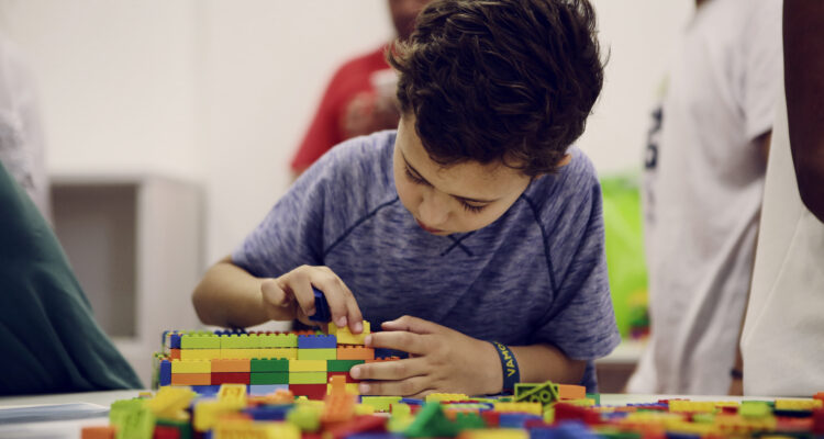 Una niño haciendo manualidades con piezas lego