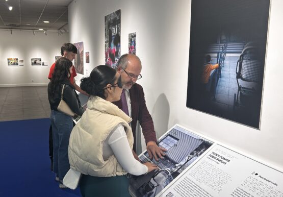 Yasmin Benslimal, estudiante, y su profesor, Antonio Martin, tocando las fotos de la exposición 