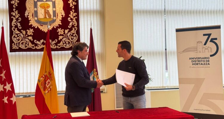 Pérez saluda a uno de los representantes de un club deportivo durante la firma