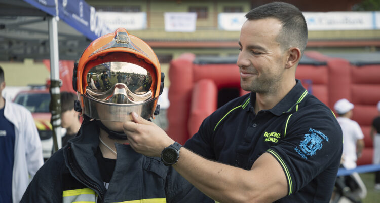 Un bombero ayuda a un niño a ponerse un casco en una de las actividades didácticas