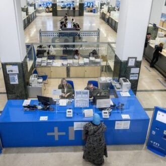 Una mujer es atendida por empleados municipales en la Oficina Integral de Atención al Contribuyente