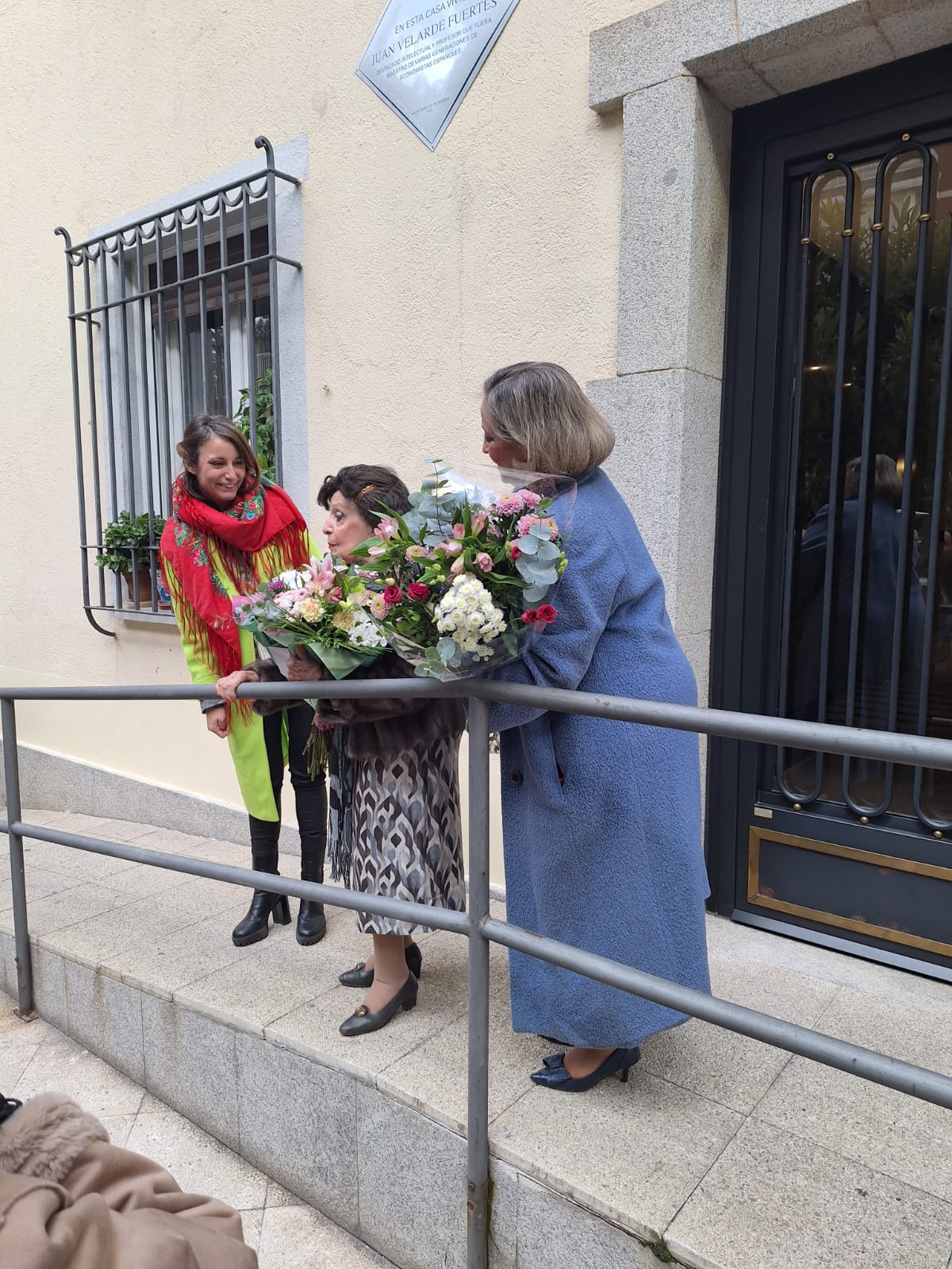 Levy descubre la placa en homenaje al economista, premio Príncipe de Asturias de Ciencias Sociales, Juan Velarde Fuertes en compañía de su viuda e hija.