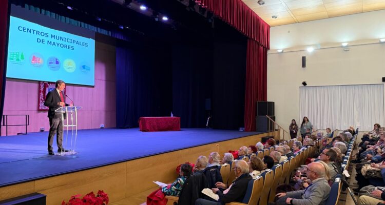 El concejal del distrito, Alberto González, en el escenario del Ausditorio Paco de Lucía, en la presentación de la Semana de Mayores, con público asistente