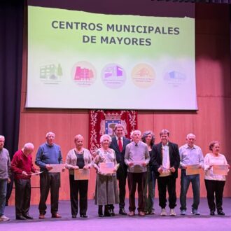 El concejal del distrito, Alberto González, en el escenario del Auditorio Paco de Lucía con las juntas directivas de los centros municipales de mayores del distrito