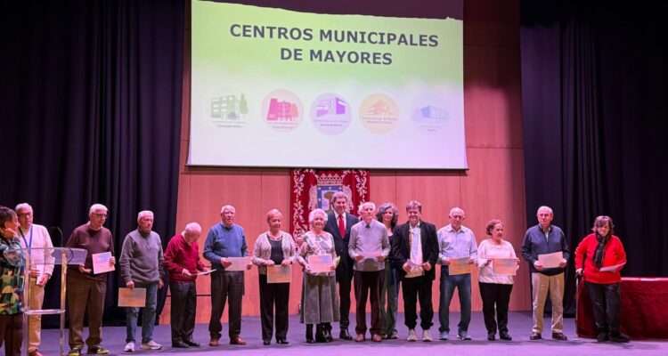 El concejal del distrito, Alberto González, en el escenario del Auditorio Paco de Lucía con las juntas directivas de los centros municipales de mayores del distrito